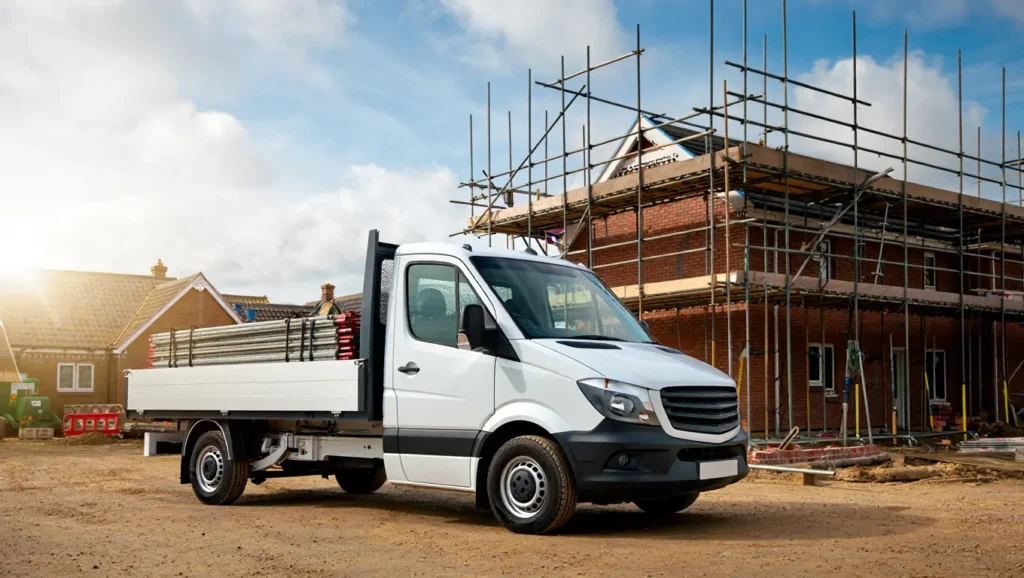 Scaffolding van parked at a construction site in Kent, loaded with long poles and boards, showcasing Hire2You's reliable van hire services for scaffolders and tradespeople.