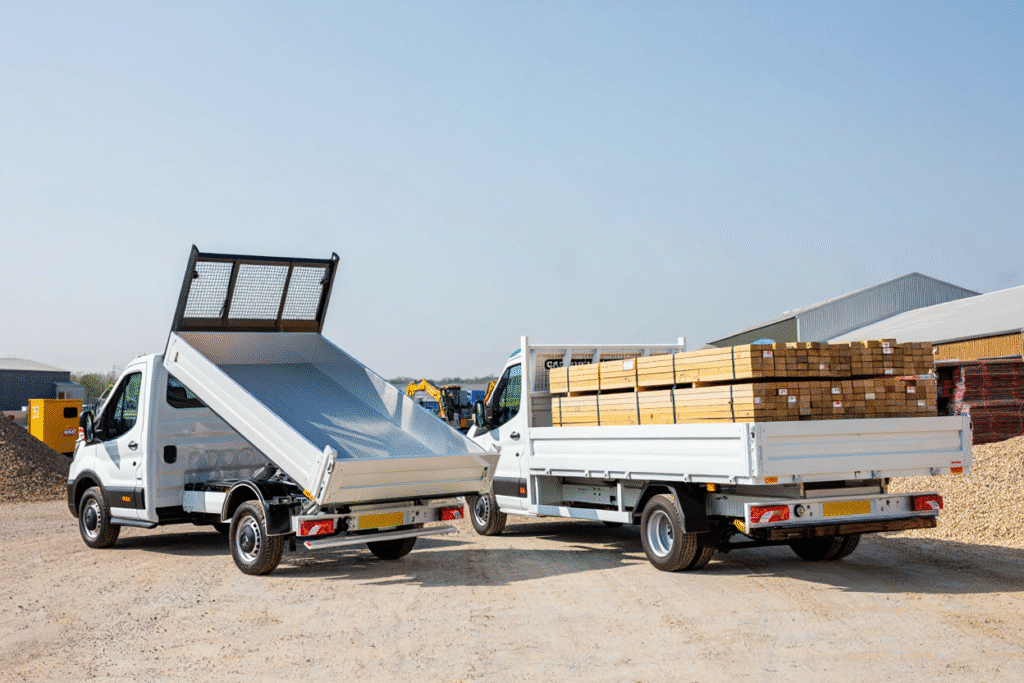 Side-by-side image of a tipper van with raised hydraulic bed and a flatbed van carrying timber, representing vehicle hire options in Tunbridge Wells.